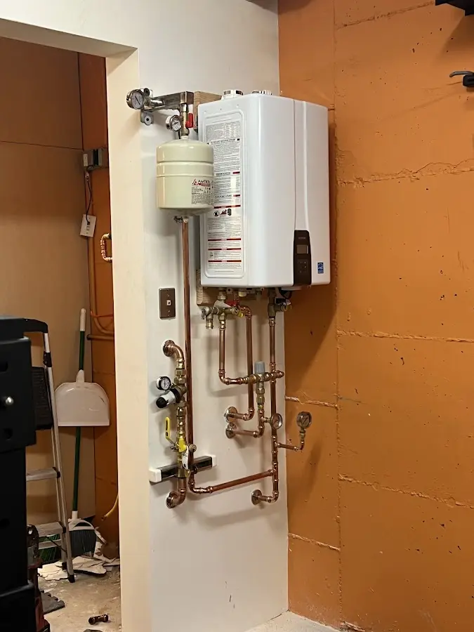 Plumbing technician inspecting water heater connections in Teague